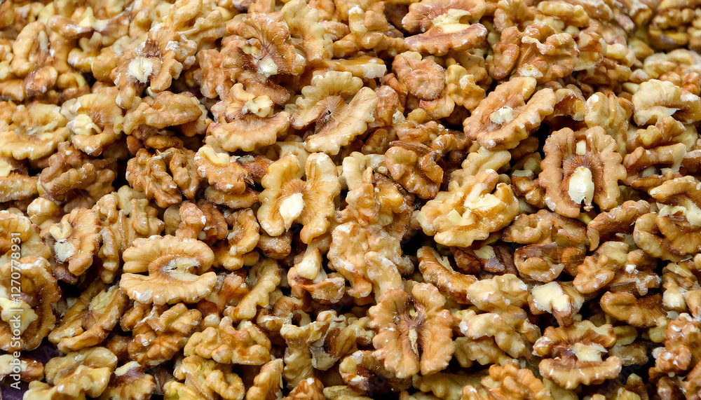Background featuring peeled walnuts texture, showcasing their smooth surface and light brown color. Ideal for healthy snacks, baking, or natural food concepts. Texture, background.