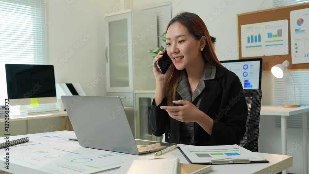 Professional businesswoman multitasking at modern workspace, managing corporate projects using laptop and smartphone while collaborating with colleagues and clients through strategic communication Professional businesswoman multitasking at modern workspace, managing corporate projects using laptop and smartphone while collaborating with colleagues and clients through strategic communication