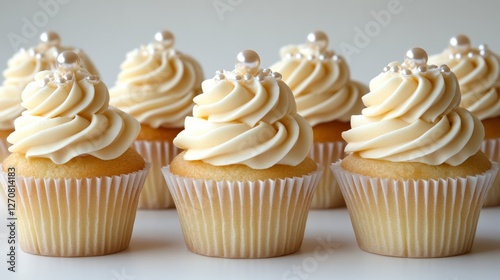 Colorful cupcakes with creamy frosting and decorative pearls arranged on a ne...