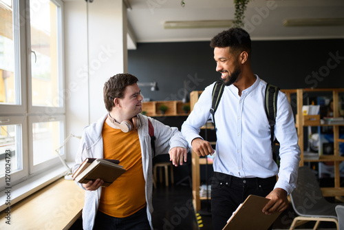 Young man with Down syndrome greeting his teacher in school. photo