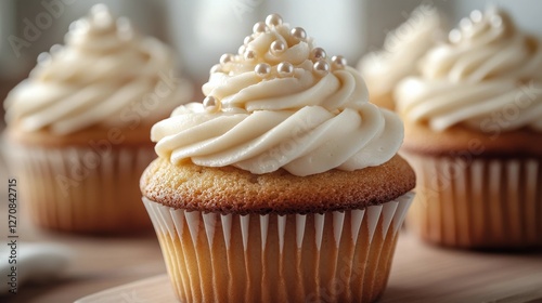 Colorful cupcakes with creamy frosting and decorative pearls arranged on a ne...