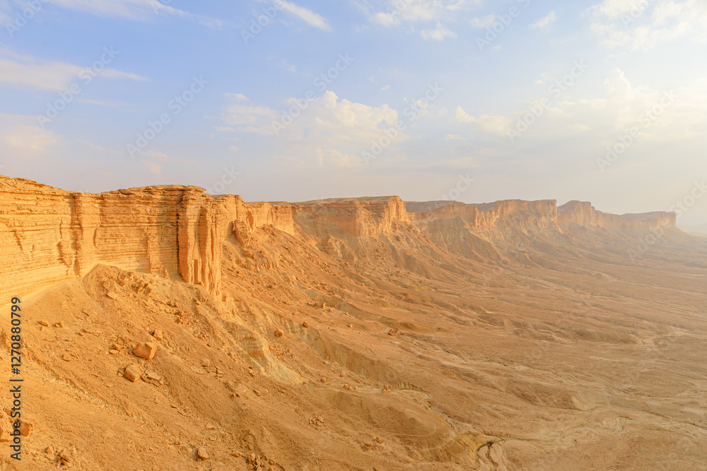 Stunning aerial view capturing the edge of the world escarpment at sunset, highlighting the dramatic cliffs of the Tuwaiq mountain range in Riyadh, Saudi Arabia