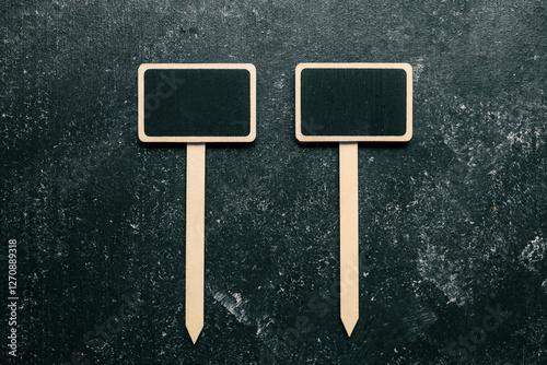 Wallpaper Mural Two blank mini chalkboard signs with wooden stakes on a dark textured background. Perfect for labeling plants, garden markers, or decorative signs Torontodigital.ca