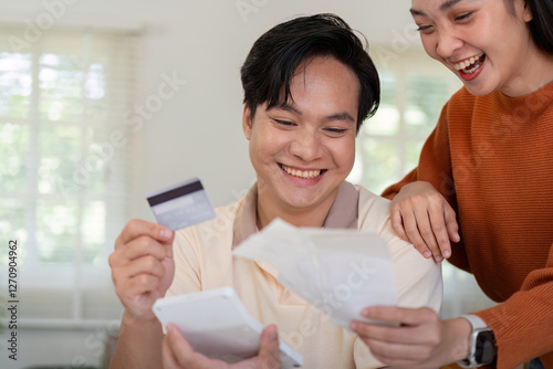 Happy couple celebrating their financial planning, reviewing bills and credit card together. photo