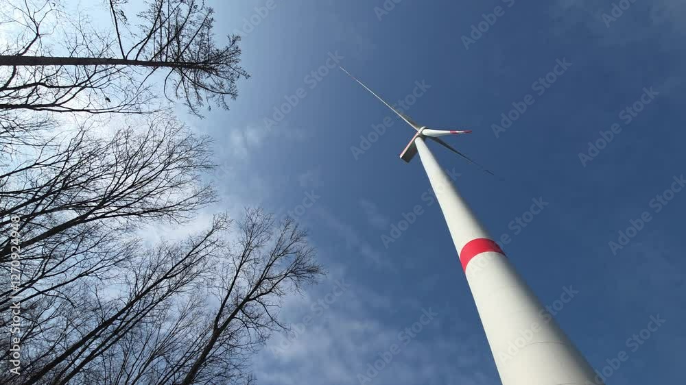Video von einer Windturbine - Windrad das sich dreht und erneuerbaren Windkraft Strom erzeugt, nach oben geschaut gegen blauen Himmel.