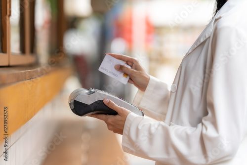 Obraz na płótnie Contactless Payment with Card: A modern individual is depicted in a close-up, using a credit card for a seamless contactless payment transaction at a point-of-sale terminal. w salonie