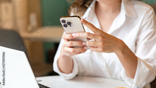 Business woman using mobile smart phone and online working on laptop computer, surfing the internet, searching the information at office. Female student online studying from home, e-learning concept