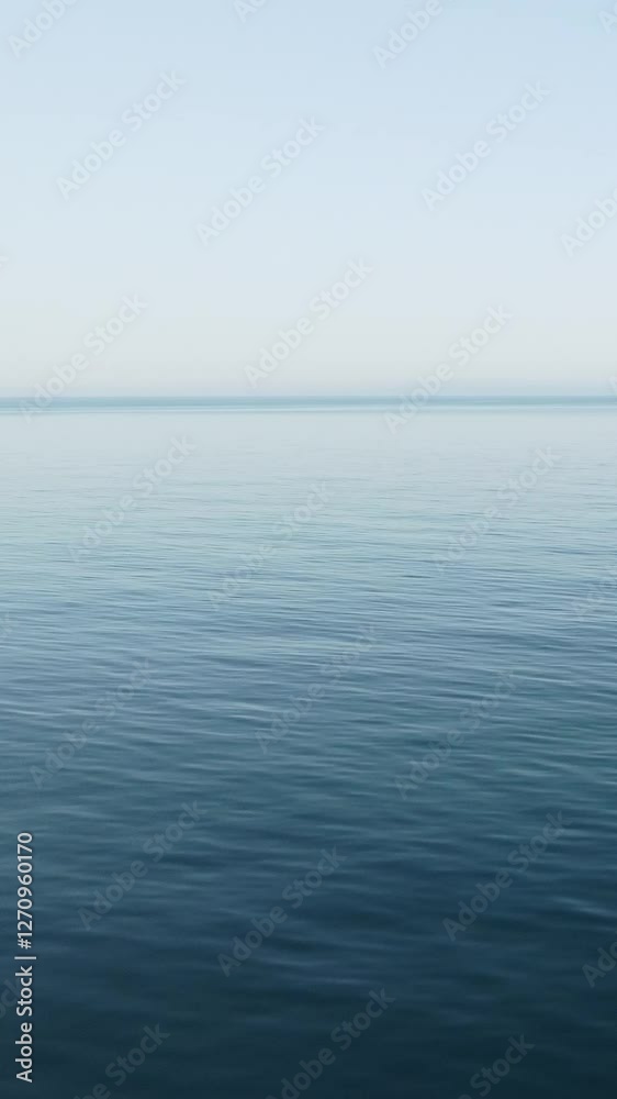 Sea water surface. Vertical aerial view, camera flies over calm sea with volcanic rocky shores. Abstract nautical summer ocean nature. Holiday and travel concept. Nobody. Weather and climate change Sea water surface. Vertical aerial view, camera flies over calm sea with volcanic rocky shores. Abstract nautical summer ocean nature. Holiday and travel concept. Nobody. Weather and climate change