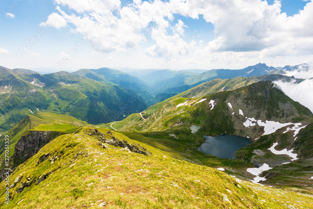 mountain landscape of romania in summer. sunny day. beautiful outdoor scenery with alpine lake. scenic view in to valley. travel background with blue sky and clouds. amazing destination for tourism