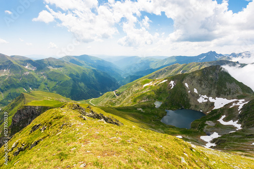 Obraz na płótnie mountain landscape of romania in summer. sunny day. beautiful outdoor scenery with alpine lake. scenic view in to valley. travel background with blue sky and clouds. amazing destination for tourism w salonie