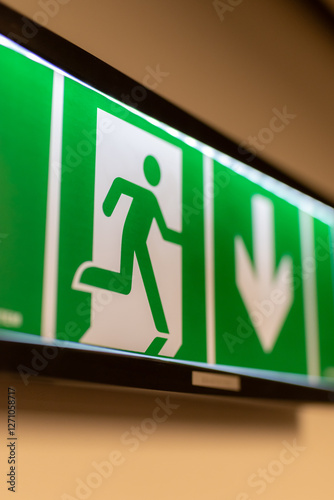 Green exit sign. Evacuation sign. Emergency exit sign with backlight in the darkness.