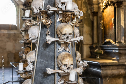 Large candlestick made of the human bones and skulls in Kostnice Sedlec Gothic chapel main hall in the Kutna Hora of Czech Republic