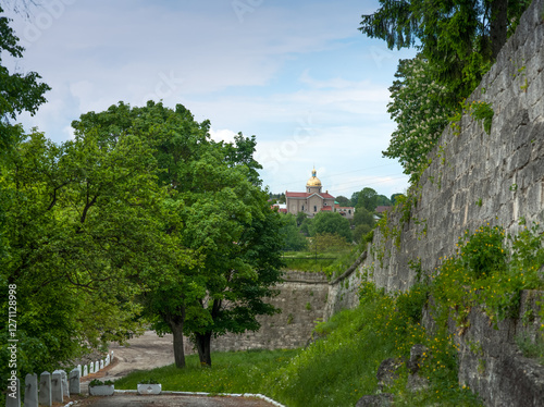 landscape with a church and a view of the historic town through the fortifica...