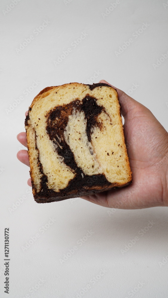 Hand holding a slice of babka brownie bread on a white background (isolated white). Hand holding a slice of babka brownie bread on a white background (isolated white).
