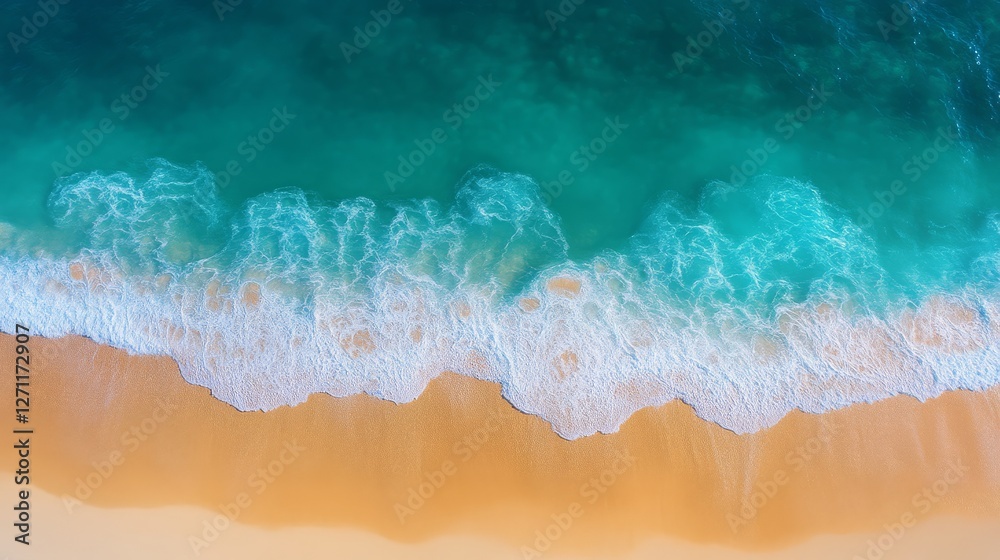 Aerial view of a serene beach with turquoise waves gently lapping against a sandy shore, creating a tranquil coastal scene.