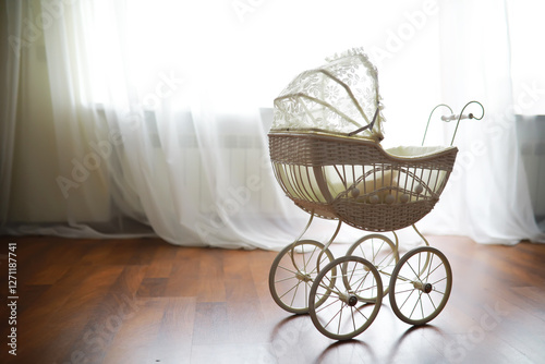 Vintage White Baby Carriage in Sunlit Room with Wooden Floor and White Curtains