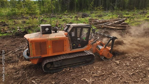 A mulcher shred organic material, leaves, branches, grass, or other plant debris, into smaller pieces. Construction of a road through the forest. Cutting and clearing of forest for road construction.