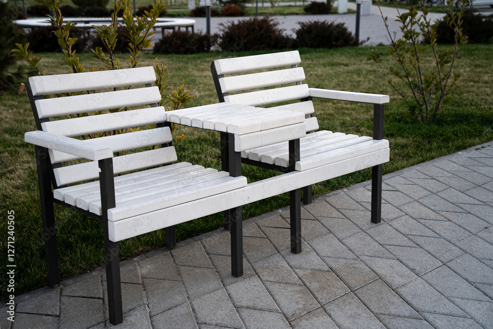 White wooden bench for two person with table in the park White wooden bench for two person with table in the park