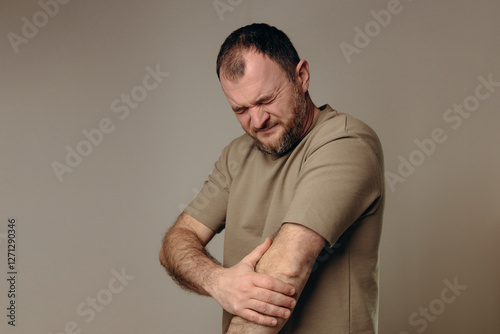  man experiences elbow pain due to joint problems, arthritis, bursitis or epicondylitis tennis elbow. diagnosis treatment, physical therapy or use of painkillers. diseases musculoskeletal system.