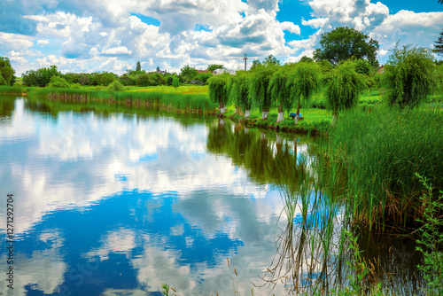 Beautiful lake with reflection on a sunny summer day. Rural landscape