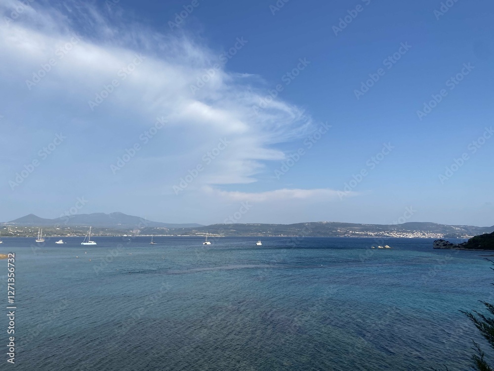 A panoramic seascape with sailboats floating on calm blue waters, framed by distant mountains. A dreamy travel destination A panoramic seascape with sailboats floating on calm blue waters, framed by distant mountains. A dreamy travel destination