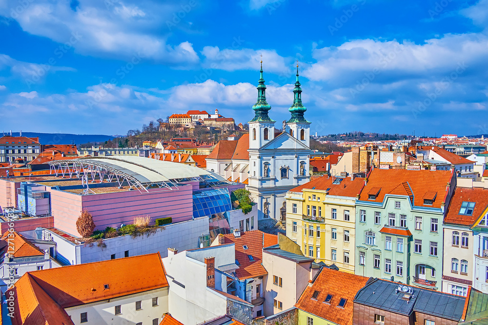 The old town of Brno with spires of Church of St Michael, modern roof of shopping mall and Spilberk citadel on background, Czech Republic
