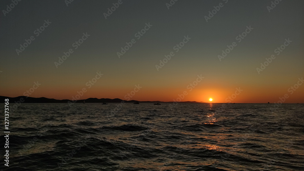 Sun setting over croatian coastline in summer evening background wallpaper copy space Sun setting over croatian coastline in summer evening background wallpaper copy space