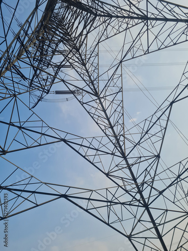 View from bottom of high voltage post or tower against clear blue sky. Electricity powerline distribution to the city. abstract composition background.