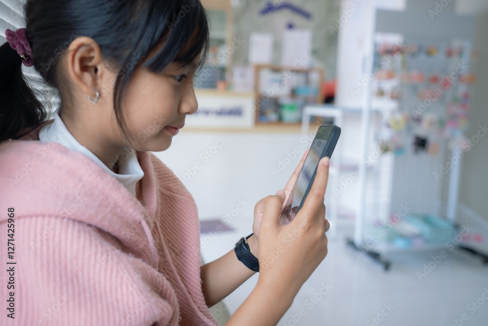 Happy young asian little girl relaxing at home.texting messaging on smartphone, smiling little girl use cellphone, chatting online message. Happy young asian little girl relaxing at home.texting messaging on smartphone, smiling little girl use cellphone, chatting online message.