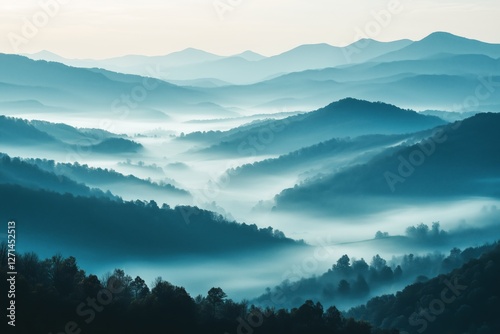 Misty mountain landscape at dawn with layers of blue hills and valleys