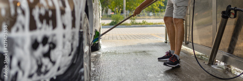 the man herself at the car wash washes the car with a brush
