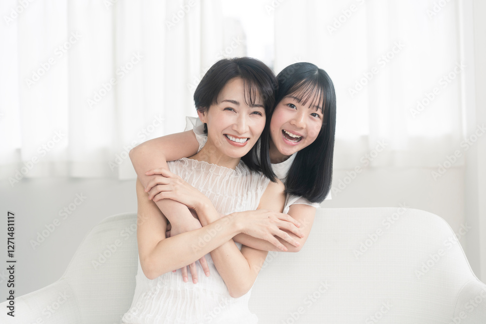 笑顔の親子/娘が母に後ろから抱きついている 笑顔の親子/娘が母に後ろから抱きついている