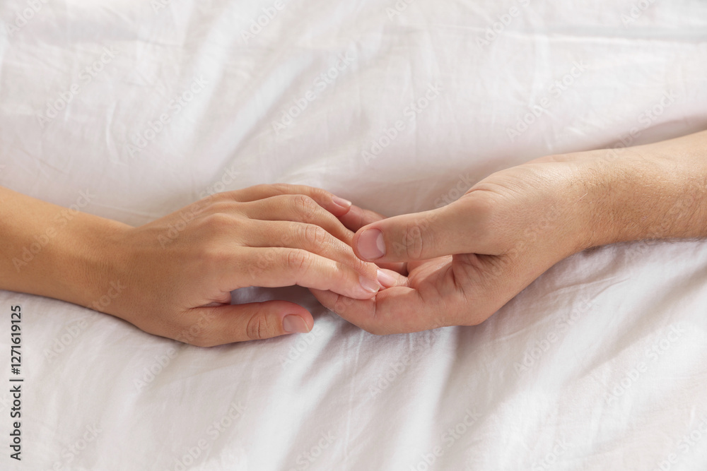 Lovely couple holding hands in bed, top view Lovely couple holding hands in bed, top view