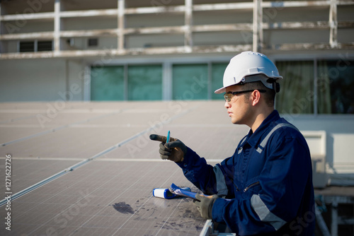 An electrical engineer is checking the heat of solar panels to make sure they are within the standard range. photo