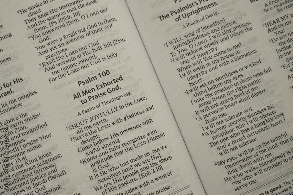 An open Bible displays Psalm 100, calling all men to praise God joyfully An open Bible displays Psalm 100, calling all men to praise God joyfully