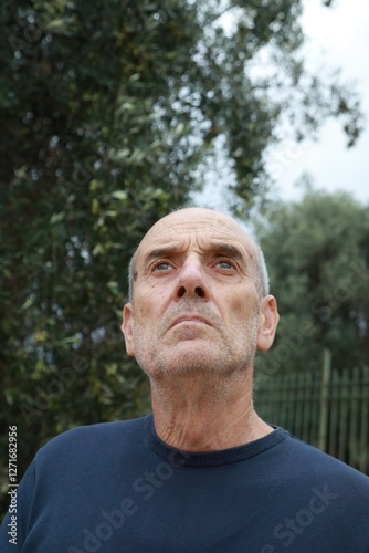Elderly Man Looks Around Suspiciously In The Park