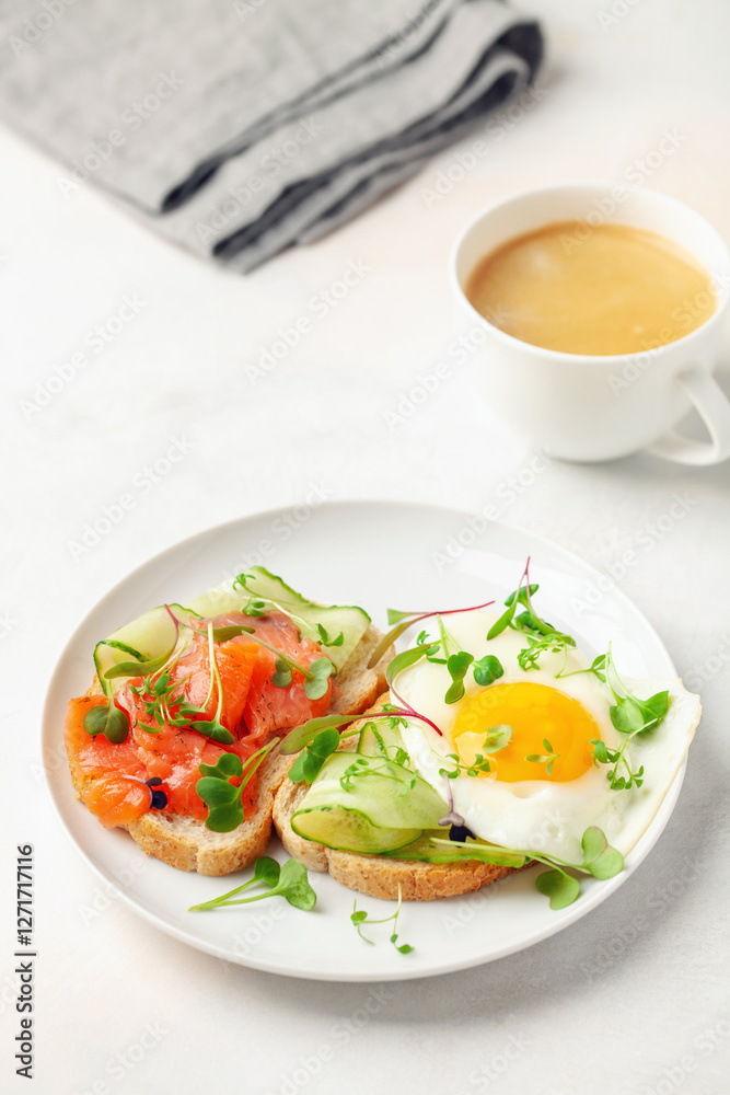 Toast with cucumber, salmon and egg in a plate on the table Toast with cucumber, salmon and egg in a plate on the table