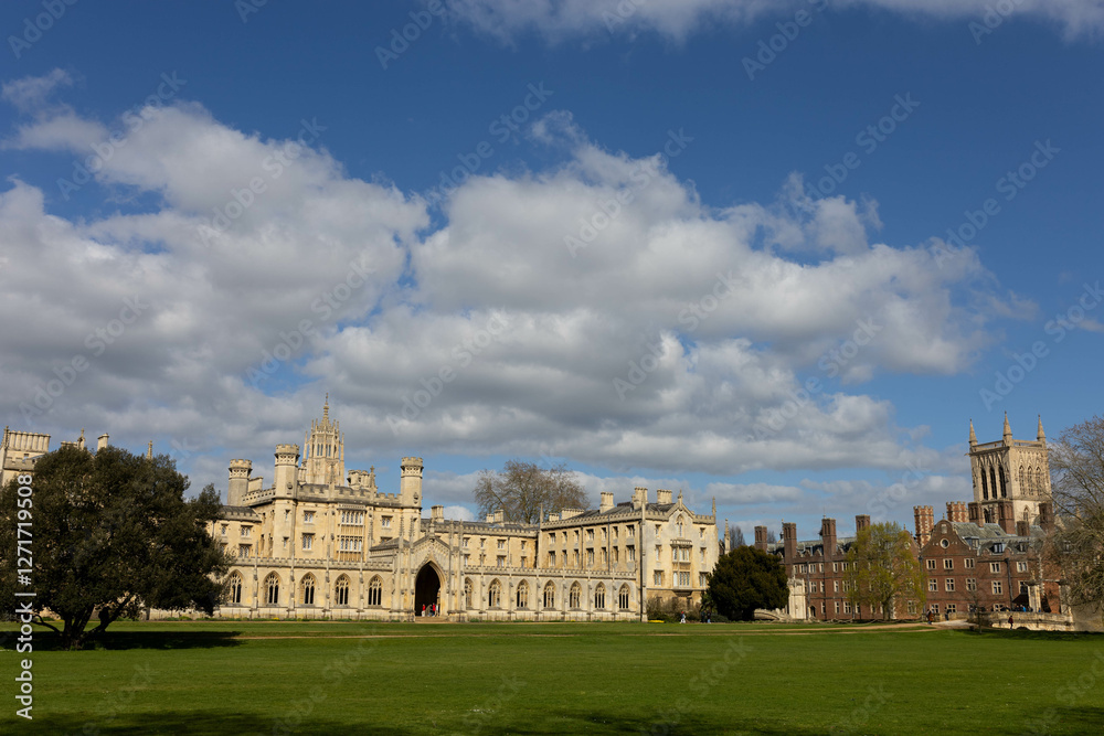 A horizontal photo taken from a distance. Historic university buildings stand proudly against a blue sky with fluffy clouds, surrounded by lush green grass on a sunny day. A horizontal photo taken from a distance. Historic university buildings stand proudly against a blue sky with fluffy clouds, surrounded by lush green grass on a sunny day.