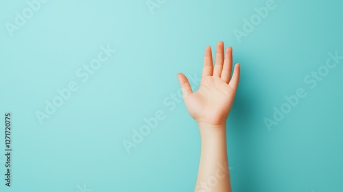 Reaching new heights, a hand striving for the top of vibrant blue wall, symbolizing ambition and goals