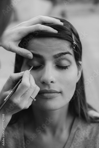 Makeup artist skillfully applies eyeliner to client's eyelid photo