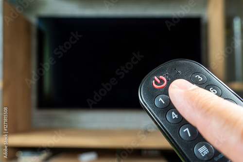 Φωτογραφία Hand holding remote control for turn off TV