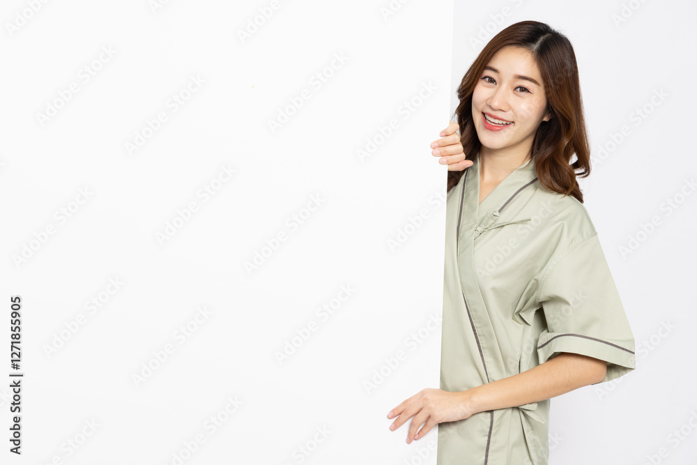 Asian woman in patient outfit smiling and showing blank white billboard advertising isolated on white background Asian woman in patient outfit smiling and showing blank white billboard advertising isolated on white background