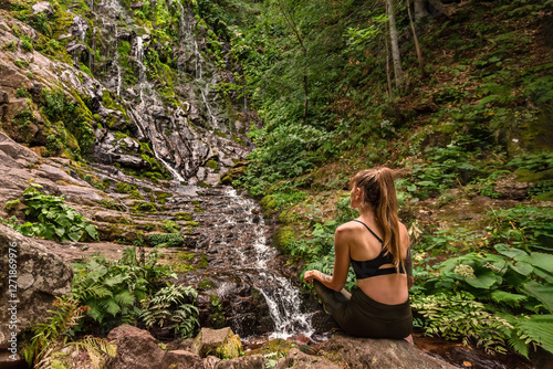 Obraz na płótnie Woman Traveler Sitting near Mountain Waterfall in Woods w salonie