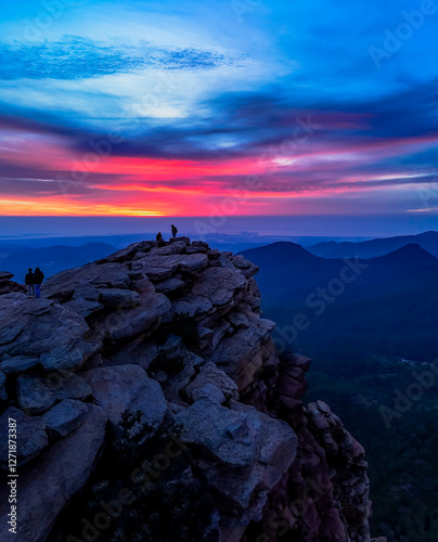 Montañero de pie en la cima de la montaña observando una vista inspiradora al amanecer. photo