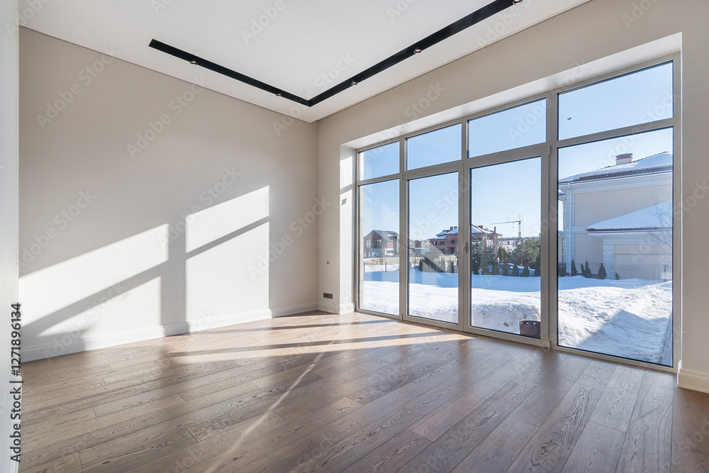 Fototapeta premium A spacious empty room in a luxurious mansion. Unfurnished. Panoramic window with a view of the winter landscape on a sunny day.