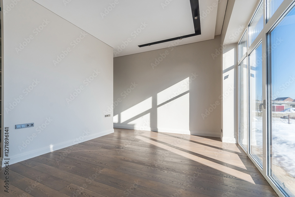 An empty room lit by the winter sun. A room with white walls, parquet floors and a panoramic window. Unfurnished. An empty room lit by the winter sun. A room with white walls, parquet floors and a panoramic window. Unfurnished.