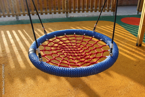 Children's swing adapted for people with physical disabilities. Kids can swing on this park game lying down or stretched out, without having to use any force. photo