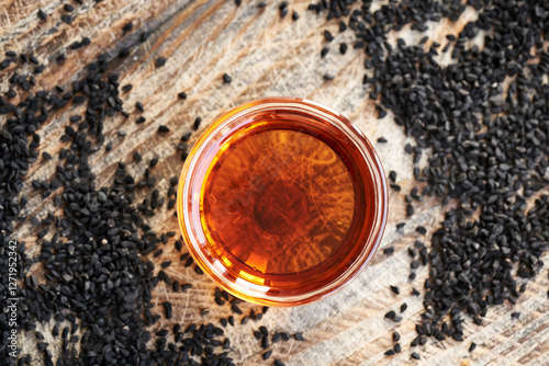 Black cumin or Nigella sativa seed oil in a glass bowl. Healthy anti-inflammatory and antioxidant supplement. photo