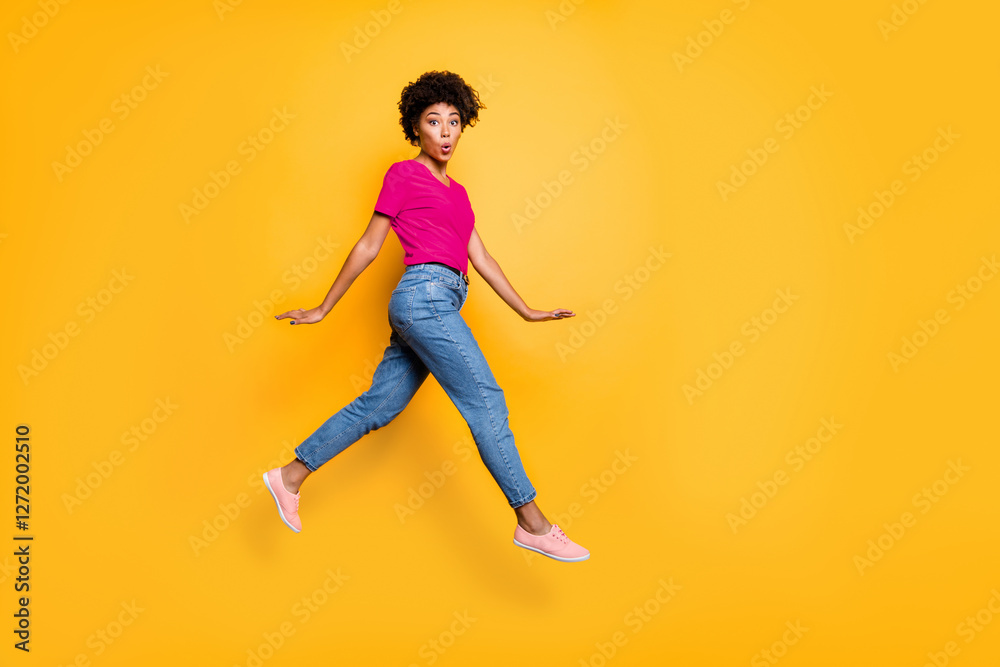 Full length body size photo of charming pretty funny cute girlfriend running away from something curly wavy wearing jeans denim isolated over yellow vivid color background Full length body size photo of charming pretty funny cute girlfriend running away from something curly wavy wearing jeans denim isolated over yellow vivid color background