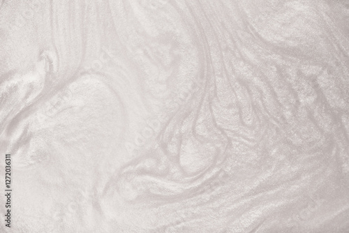 Shimmering silver abstract background. Liquid glitter paint texture waves and swirls. Beautiful shiny white glitter texture. Metallic silver paint close-up as a holiday background.